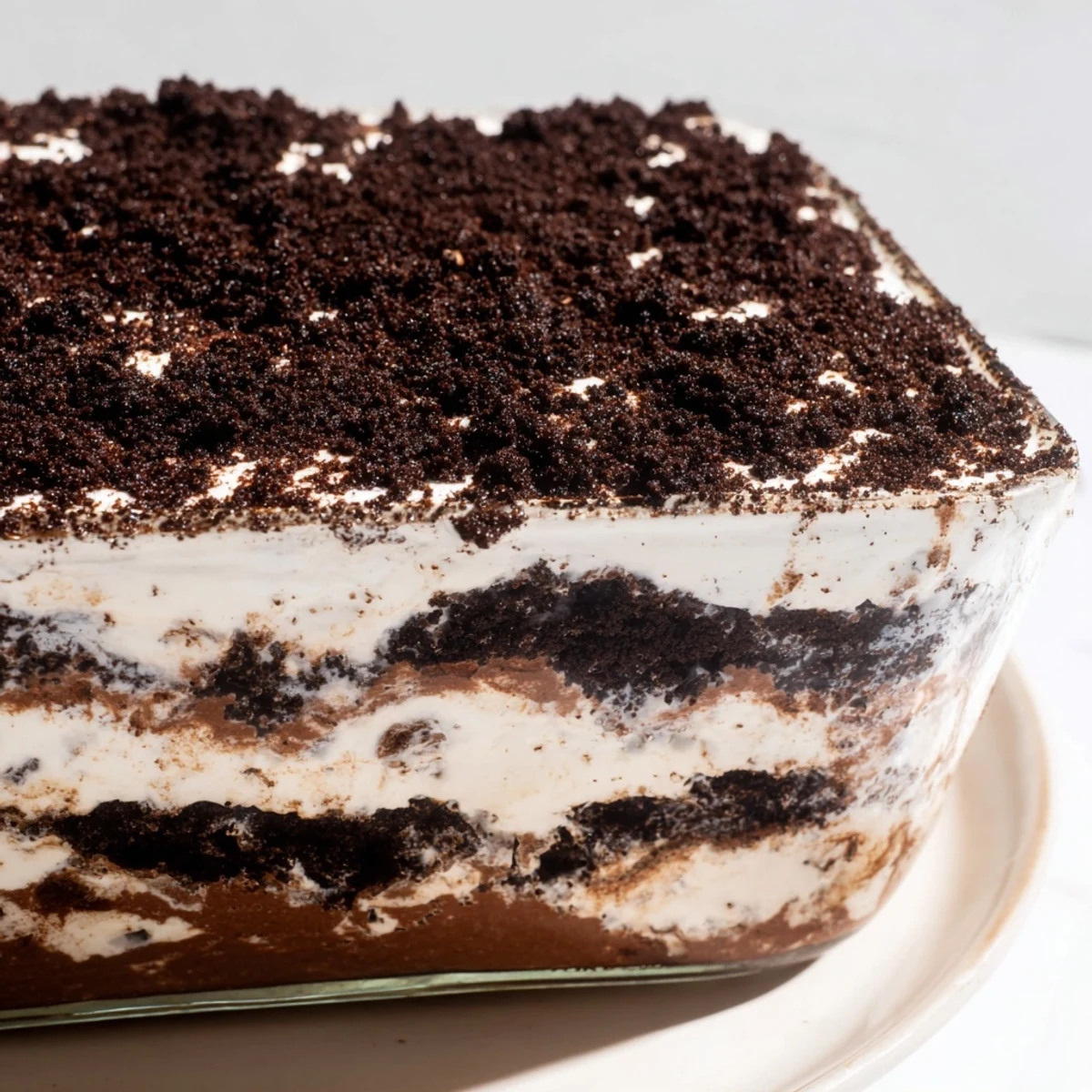 Keto dirt cake layered in glass jar with chocolate pudding, whipped cream, and almond crumble topping