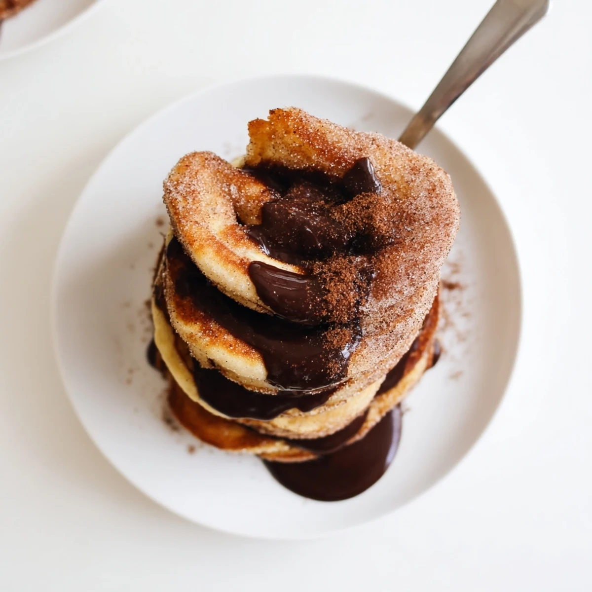 Golden Spanish Churro Pancakes coated in cinnamon sugar ready for chocolate dipping