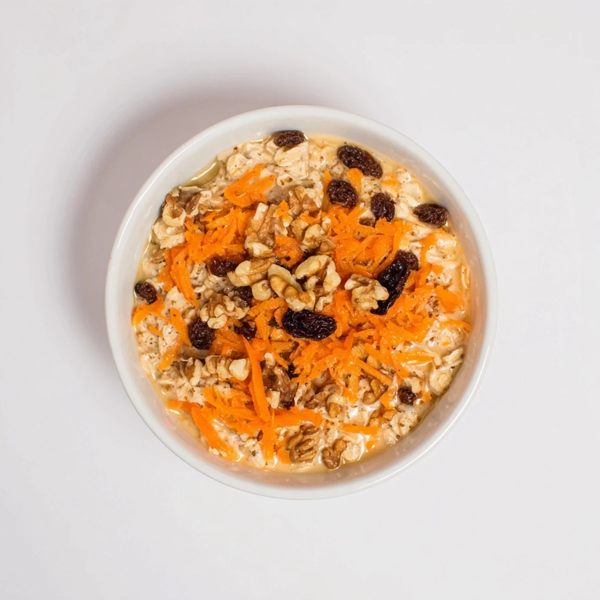 Carrot Cake Overnight Oats in a glass jar topped with crunchy walnuts and a sprinkle of warm cinnamon