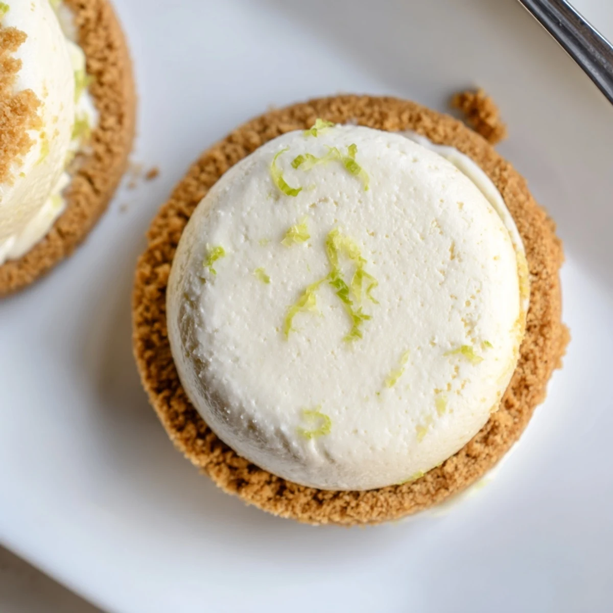 Chilled Key Lime Pie Ice Cream Sandwiches served on parchment, sprinkle of lime zest