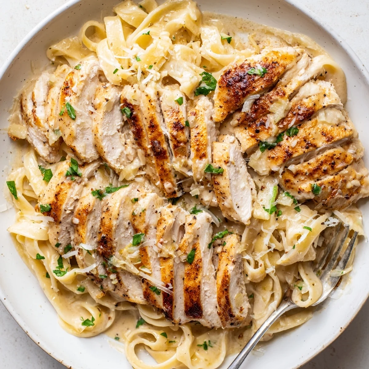 Creamy Garlic Chicken Pasta plated with parsley garnish, steam rising, ready to eat