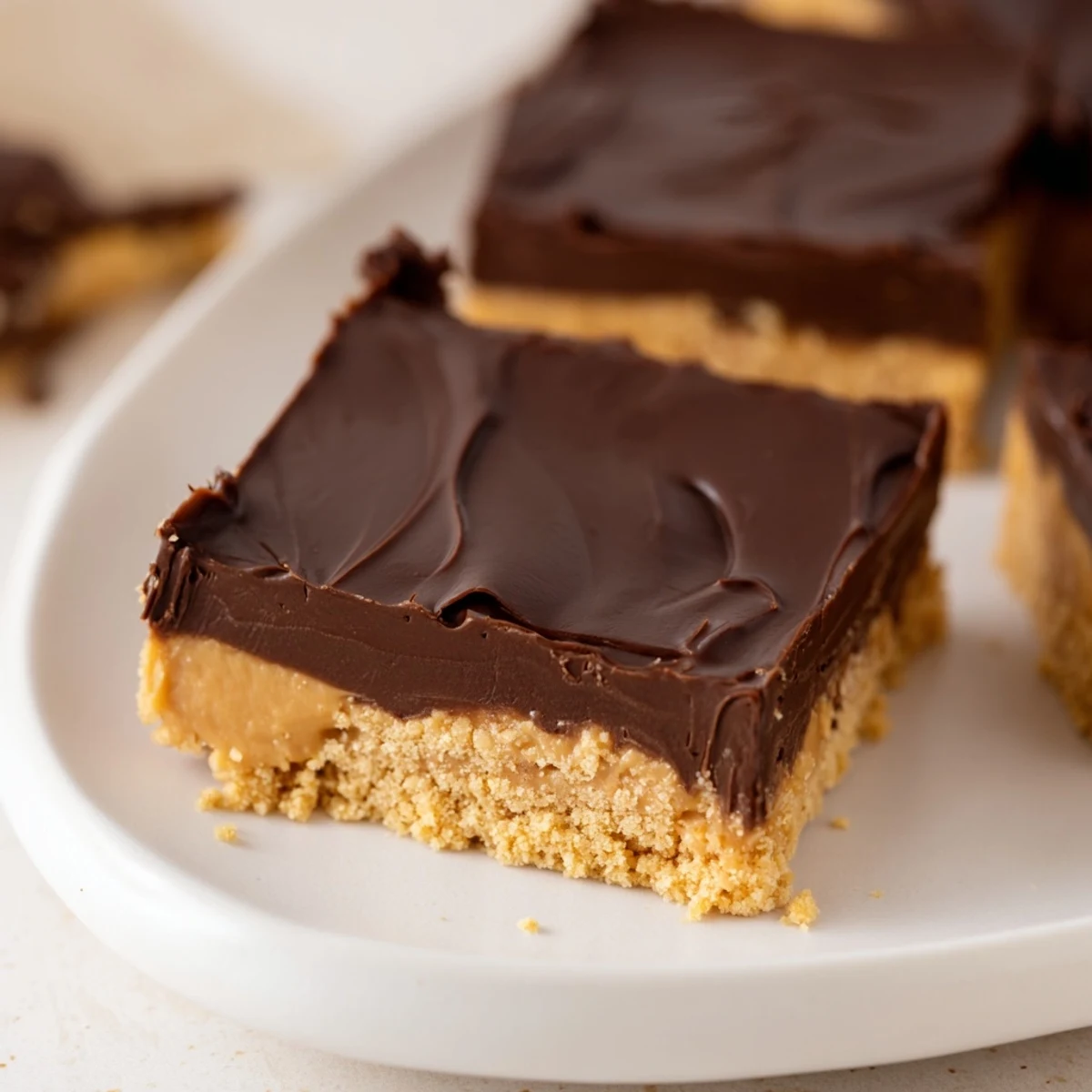 Creamy No Bake Peanut Butter Bars topped with melted chocolate, sprinkled sea salt